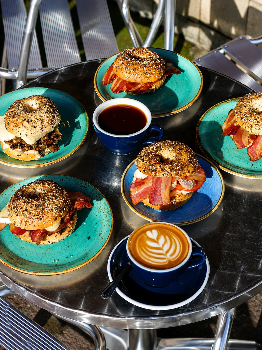 A spread of bagels and coffee on an outdoor table